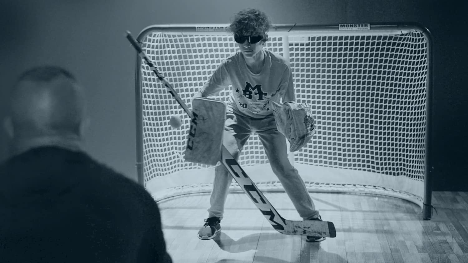 A young hockey player uses Senaptec glasses in a hockey net.